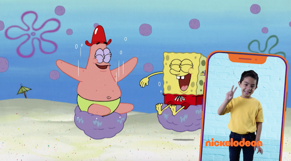 Bob Sponge & Patrick laugh while they are each seated on a bouncing cushion. Over the image, on the right, a cellphone screen shows a boy doing sign language.